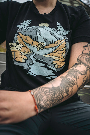 Woman wearing the black Adventure Together shirt from Loblola. You can see her tattooed left arm.
