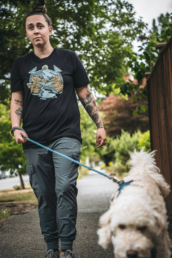 Woman walking her white dog wearing the black Adventure Together shirt from Loblola. 