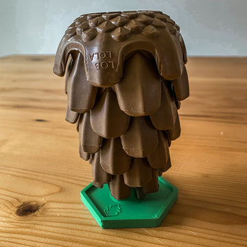 The Loblolly Pinecone Dog Toy upside down on the Stopple Stand. The Stopple Stand is green.